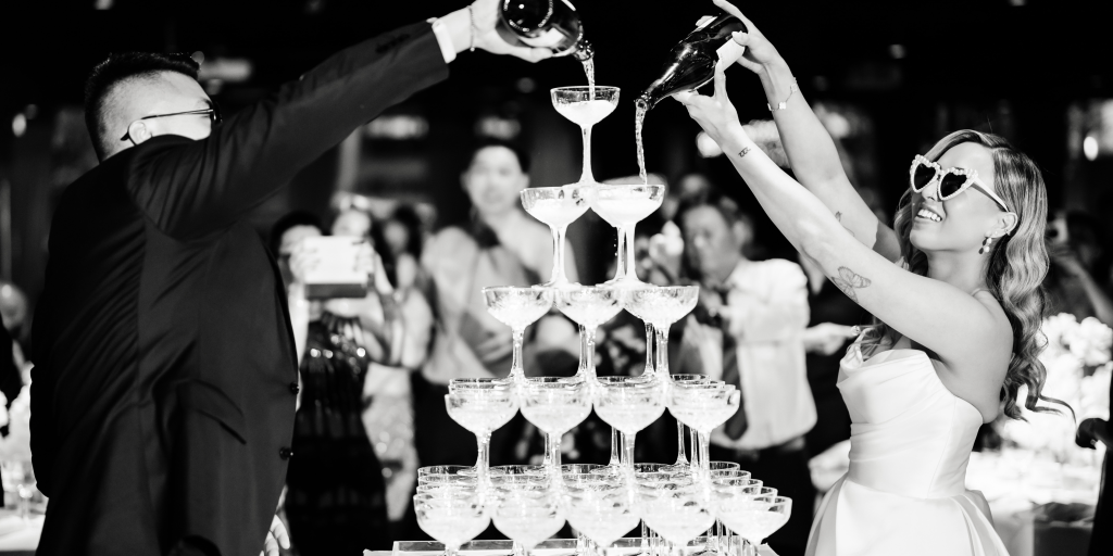 Couple with a champagne tower at their last minute wedding